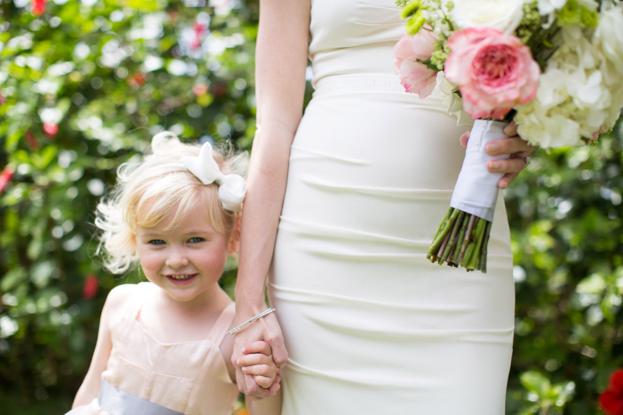A picture of a flower girl holding a brides hand.