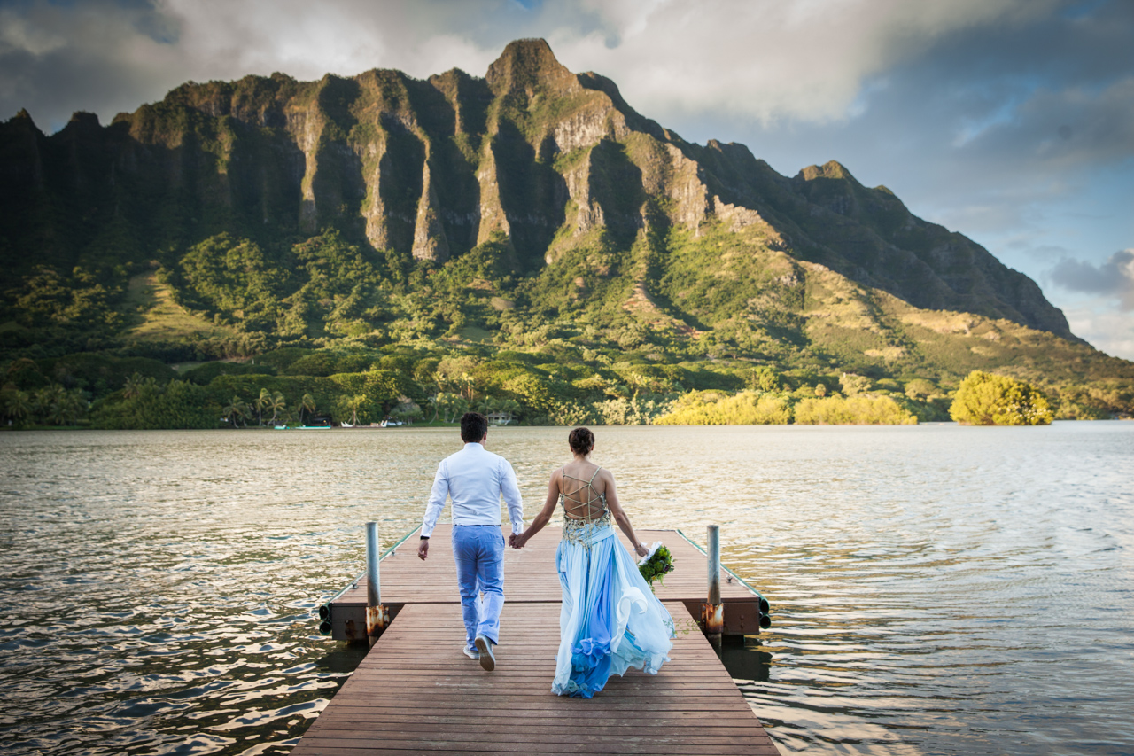 Picture of a couple walking to the end of a pier at Kualoa ranch, Oahu, Hawaii.