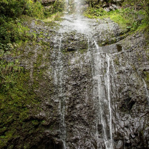 A couple in love swim in a waterfall in Hana, Maui.