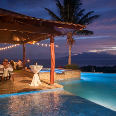 An image of a wedding venue in Launiapoko Maui at sunset with a lighted pool.