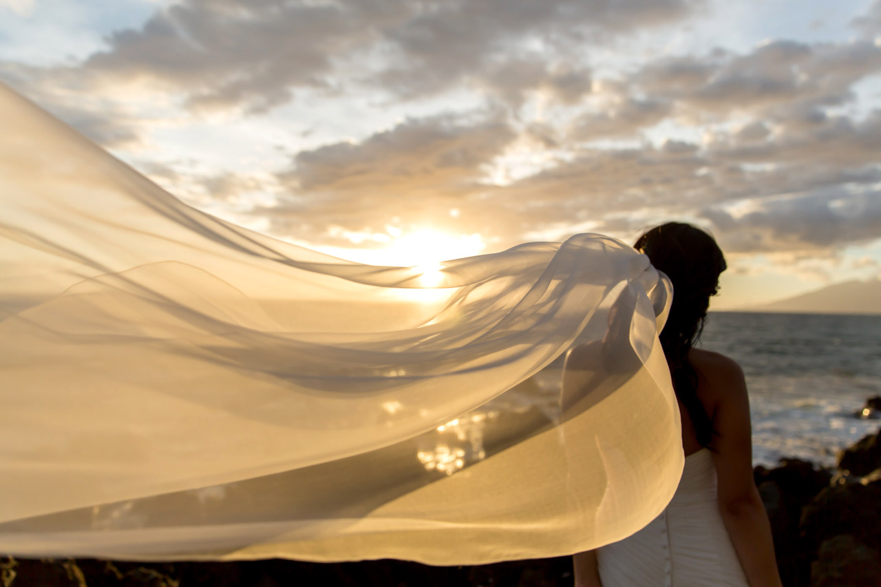 brides veil blowing in the wind with a maui sunset in the background