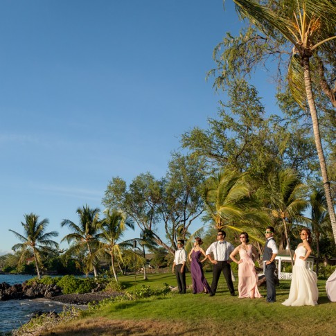 Panoramic photo of a wedding party posing on the waters edge in Makena, Maui.