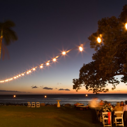 A panoramic photo of an evening wedding reception at Olowalu Plantation Houose in Maui.