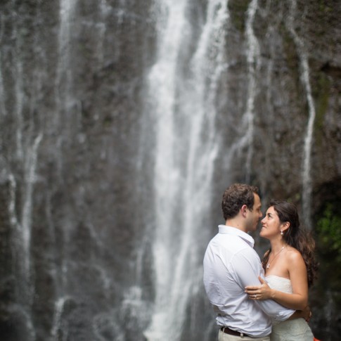 couple holding each other set against Wailua Waterfall on Maui