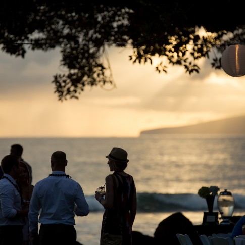 silhouettes of wedding guests enjoying the view of Lanai at sunset from the Olowalu Plantation Hoouse