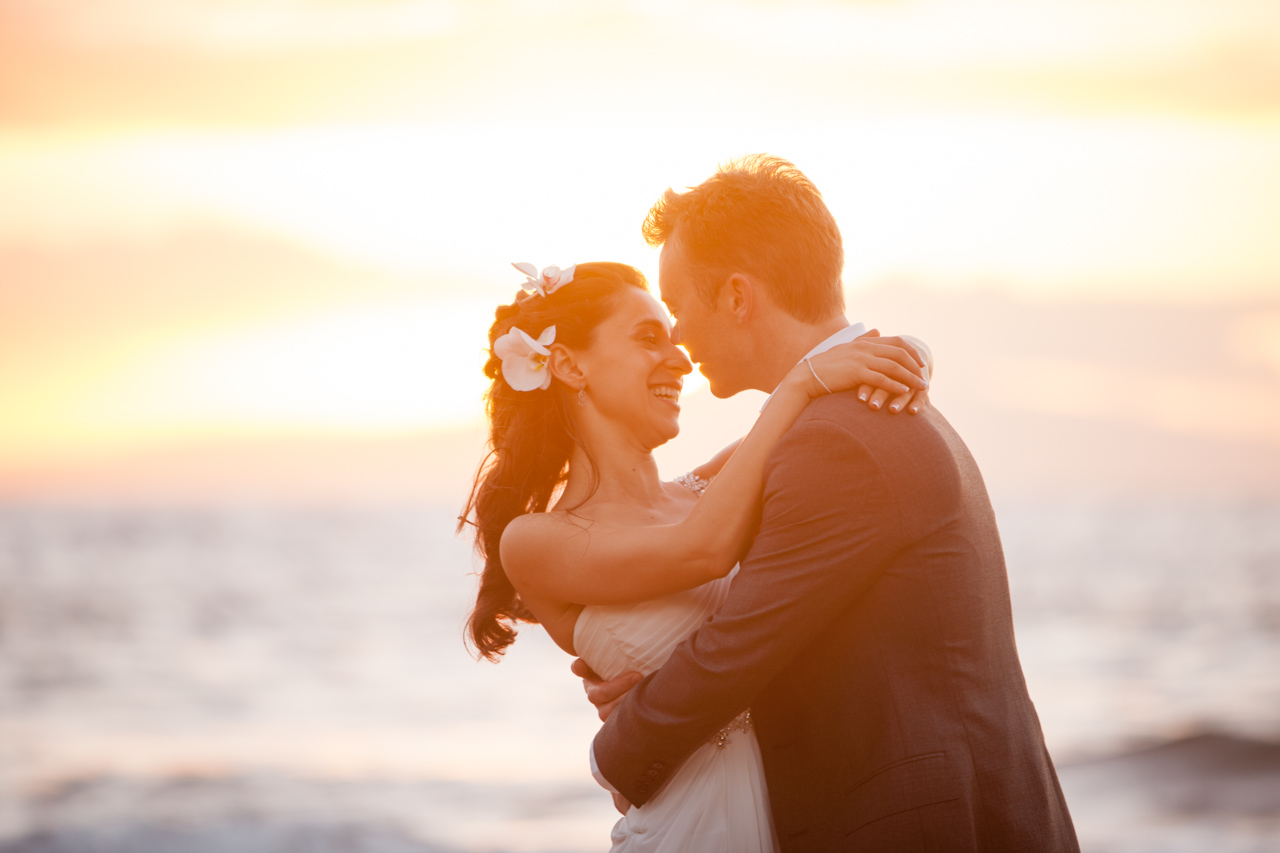 photography of a wedding couple embracing in the golden hue of a maui sunset