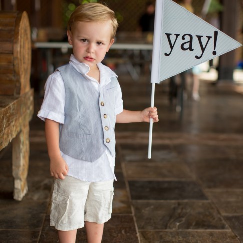 Young wedding guest in boat shoes with a sign that says YAY