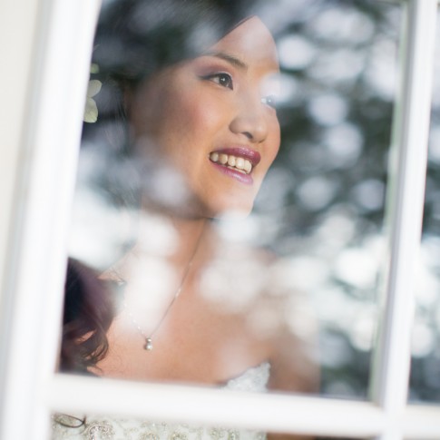 a bride looks out a window before her wedding in hawaii