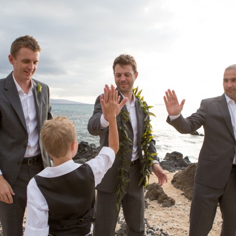 Groomsmen high living the ring bearer after a wedding ceremony in Makena Maui.