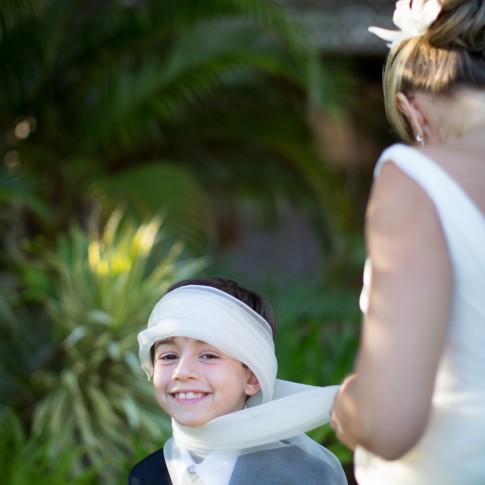 A young boy at a wedding gets wrapped in the brides veil.